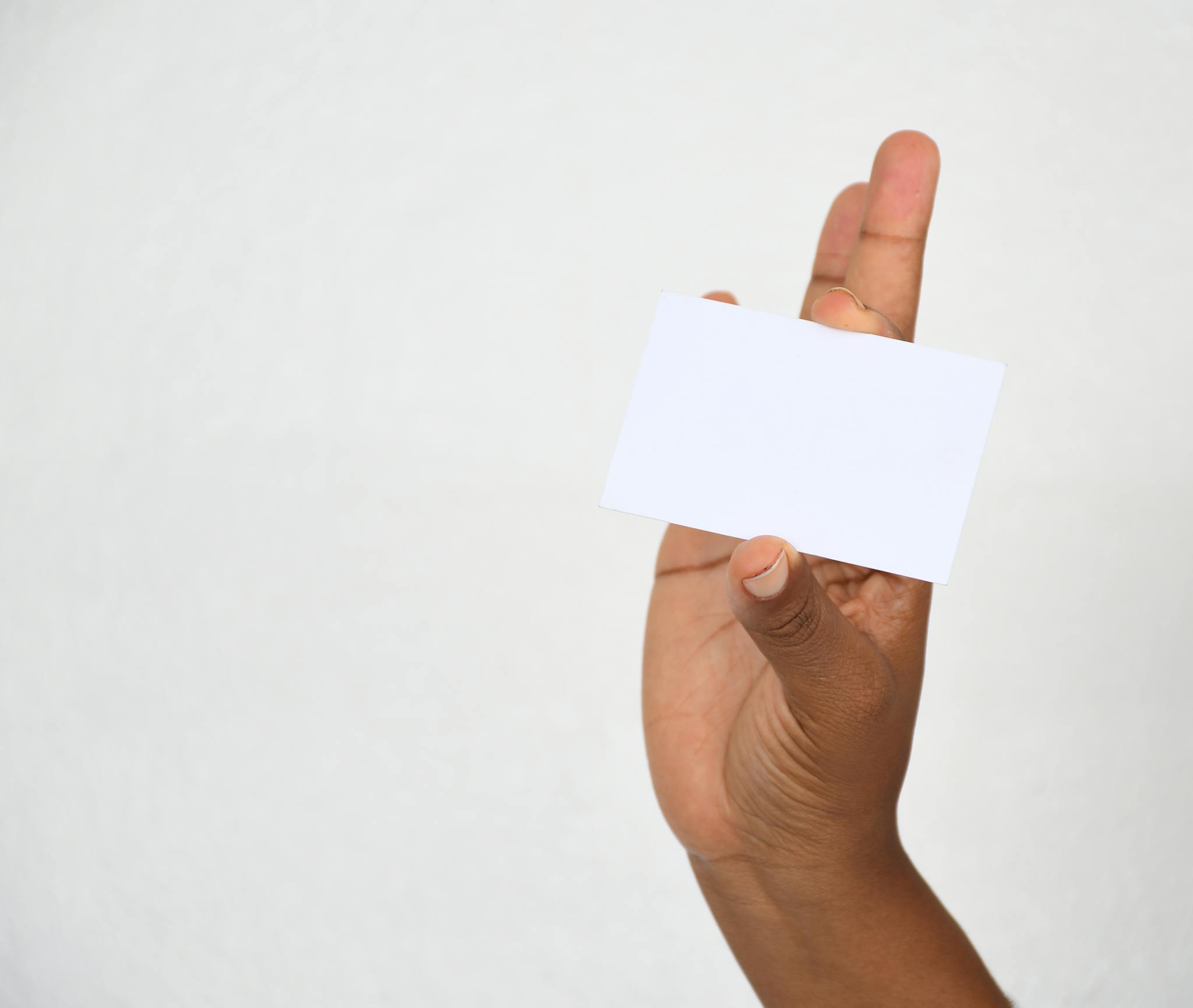 A close-up of a hand holding a blank card, ideal for copy space.