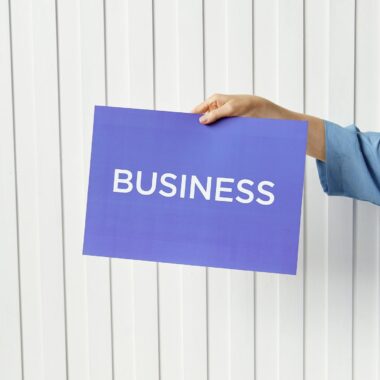 A hand holds a blue placard with 'Business' signage against a white background, ideal for startup themes.