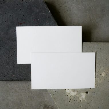 Simple flat lay of blank business cards on textured concrete background. Perfect for modern design presentations.