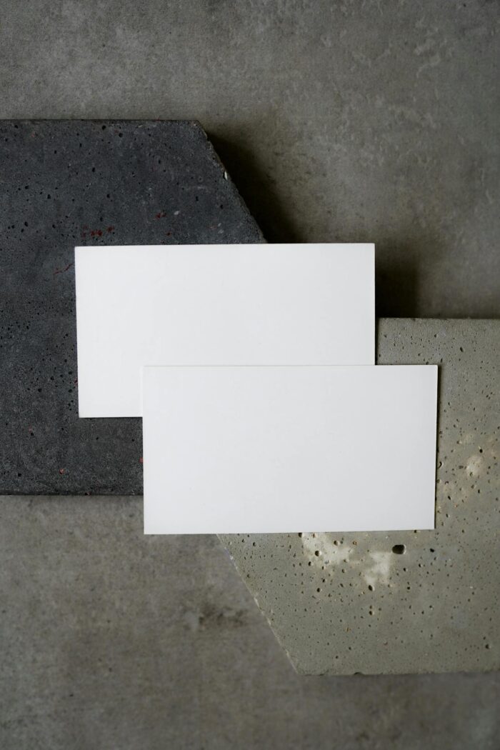 Simple flat lay of blank business cards on textured concrete background. Perfect for modern design presentations.